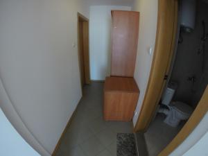 a small bathroom with a toilet and a wooden cabinet at Hotel Filland in Sozopol