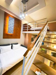 a bedroom with a bed and a staircase with a window at 天天泡湯 in Yilan City