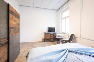 una camera con letto, scrivania e TV di Epicenter - rooms & terrace a Lubiana
