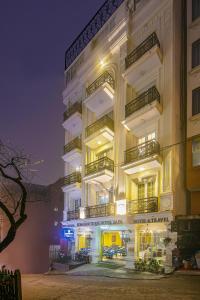 a tall white building with balconies at night at Eden Boutique Hotel & Spa in Sa Pa