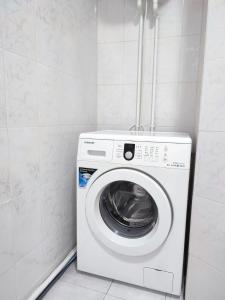 - Lavadora y secadora en una habitación pequeña en Апартаменты Жаяу Мусы 7А, en Pavlodar