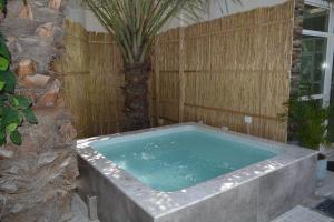 a hot tub in a backyard with a wooden fence at Dar 66 Pool Chalets with Jacuzzi in Ras al Khaimah