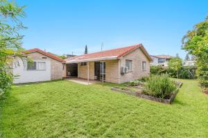 una casa con un patio delante de ella en Seashells - Popular Beach House, en Yamba 3 fotos más