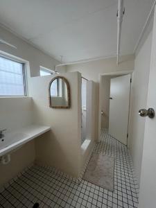 y baño con lavabo y espejo. en The Espy Hostel en Cairns