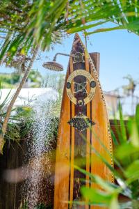 una tabla de surf de madera sentada junto a una fuente de agua en Seashells - Popular Beach House, en Yamba