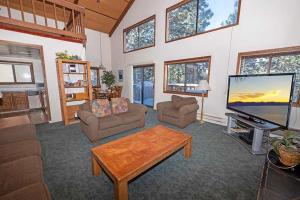 a living room with a flat screen tv and a table at 1228 Timber Lane home in South Lake Tahoe