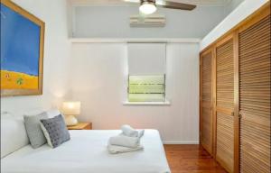 um quarto com uma cama branca e uma janela em Villa Marshall em Machans Beach