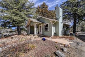 a small green house with trees in front of it at Pet Friendly and Historic Prescott Home with Fire Pit! in Prescott