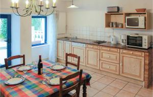 a kitchen with a table and chairs and a kitchen with a table and a table at Stunning Home In Cadouarn With 2 Bedrooms, Wifi And Outdoor Swimming Pool in Séné