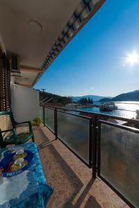 a balcony with a table and a view of the water at Apartments Vučinović in Tivat