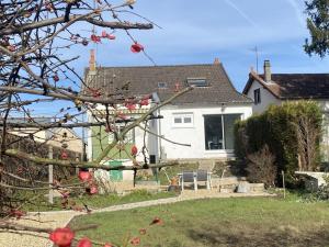 een wit huis met rode appels aan een boom bij Gîte Moulins, 4 pièces, 6 personnes - FR-1-489-439 in Moulins