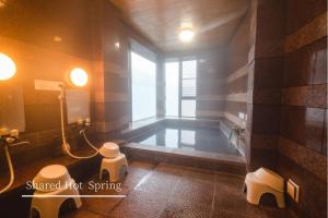 un bagno con vasca in una camera con finestra di Guest House Takiyoshi a Hongu