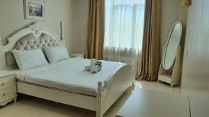 瓜埠的住宿－Simfoni Resort Langkawi，一间卧室配有一张白色大床,床上有鲜花