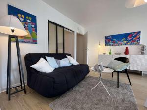 een woonkamer met een zwarte bank en een tafel bij Appartement Bénodet, 2 pièces, 2 personnes - FR-1-481-136 in Bénodet