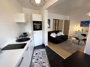 een keuken en een woonkamer met een bank bij Appartement Bénodet, 2 pièces, 2 personnes - FR-1-481-136 in Bénodet
