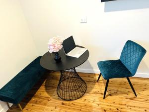 a table with a laptop and two chairs in a room at Seven Inn in Wagga Wagga