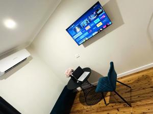 a living room with a tv and a table and a chair at Seven Inn in Wagga Wagga