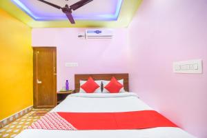 sypialnia z łóżkiem z czerwonymi poduszkami w obiekcie Flagship Black Diamond Hotel and Restaurant Barasat w mieście Bārāsat