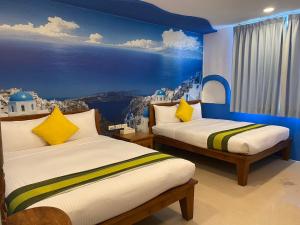 a bedroom with two beds with a painting on the wall at Kenting Sin Sin Hotel in Kenting