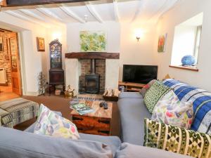 a living room with a blue couch and a fireplace at Carter's Cottage in Stow on the Wold