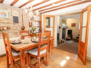 a dining room with a wooden table and chairs at Carter's Cottage in Stow on the Wold