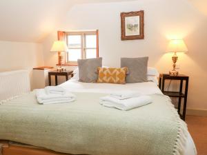 a bedroom with a large bed with towels on it at Carter's Cottage in Stow on the Wold