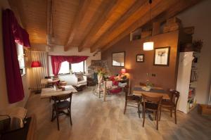 een woonkamer met houten plafonds en tafels en stoelen bij Maison d'hôtes Victoret in Challand Saint Victor