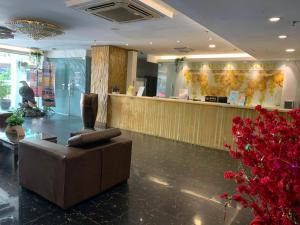 a lobby with a couch and a counter with flowers at Simfoni Resort Langkawi in Kuah