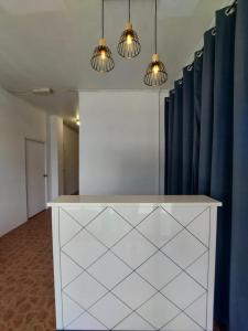 um balcão branco num quarto com cortinas azuis em Warisan Family inn @ Seafront em Semporna