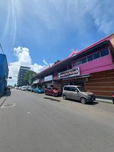 a street with cars parked in front of a building at Warisan Family inn @ Seafront in Semporna