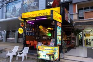una casa fusion con sedie bianche di fronte a un negozio di Krabi Freedom Hostel and Bar ad Aonang Beach