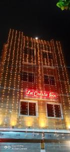 ein beleuchtetes Gebäude mit einem Neonschild darauf in der Unterkunft LA CRESTA INN in Kalkutta