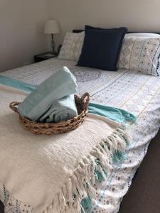 a basket of towels sitting on top of a bed at Heart of Torquay - Whitewater Apartment - Torquay in Torquay