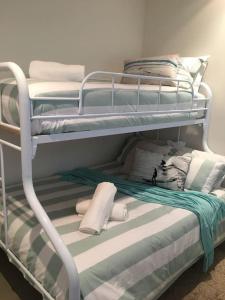 a couple of bunk beds with towels and pillows at Heart of Torquay - Whitewater Apartment - Torquay in Torquay