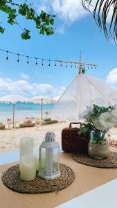 沙美島的住宿－Kerala Coco Resort，一张带蜡烛的桌子和海滩上的帐篷
