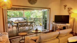 a living room with a couch and a table with chairs at Magnetic Mango Escape in Horseshoe Bay