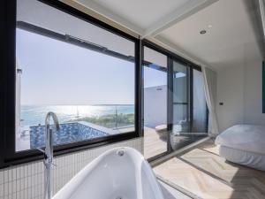 a bathroom with a tub and a view of the ocean at Kenting Sea Wall 130 in Kenting