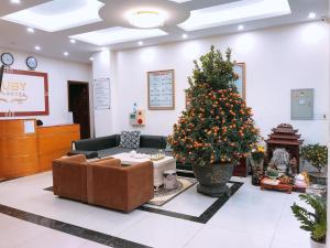 a living room with a christmas tree and a couch at Ruby Hotel in Nam Ðịnh