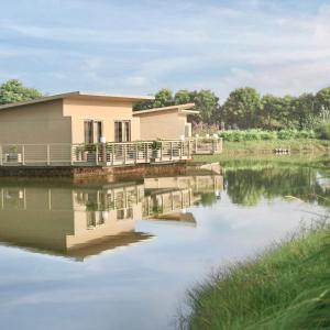 a house on a dock over a body of water at Life At REPOSE- Lake Villas Resort & Club in Chor Warodra