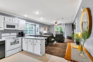 a kitchen with white appliances and a dining room at Cozy Lakeside Getaway - Outdoor Theater - Free Early Check-In- 4min to Silver Dollar City in Branson
