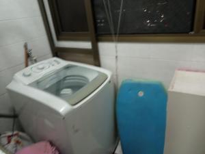 a washing machine in a small bathroom with a window at Apto Pé na Areia Próx Centro Boqueirao PG in Praia Grande