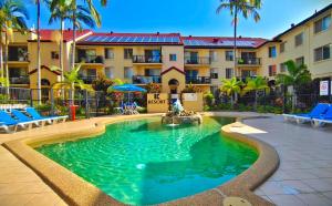- une piscine en face d'un bâtiment avec des palmiers dans l'établissement K Resort Surfers Paradise Apartments, à Gold Coast