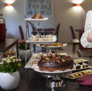 a buffet of pastries and cakes on a table at Hotel Nuvò in Naples