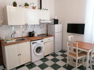 a small kitchen with a washing machine and a table at Eco Pisa Tower Guesthouse in Pisa +30 photos