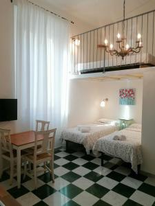 a bedroom with two beds and a table and a desk at Eco Pisa Tower Guesthouse in Pisa