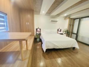 een slaapkamer met een wit bed en een tafel bij Gemini Saigon BOUTIQUE in Ho Chi Minh-stad