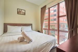 a bedroom with a bed and a large window at Swing & Pillows - Adya Hotel Kuala Lumpur in Kuala Lumpur