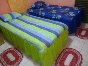 a couple of beds in a room with a bedskirts at Apto Pé na Areia Próx Centro Boqueirao PG in Praia Grande
