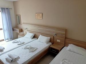 two beds in a hotel room with towels on them at ROMANTZA apartments in Agia Marina Nea Kydonias