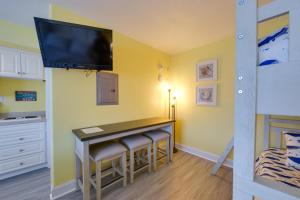 a small kitchen with a table and a tv on the wall at Ocean City Condo with Pool Walk to Boardwalk! in Ocean City
